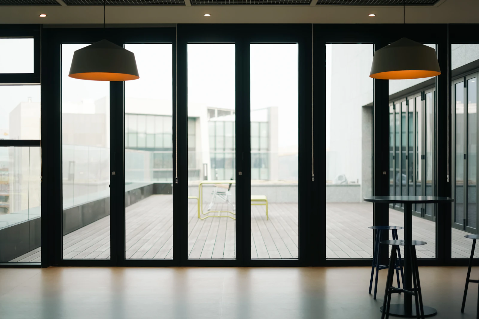 A room with a table, chairs and a large window