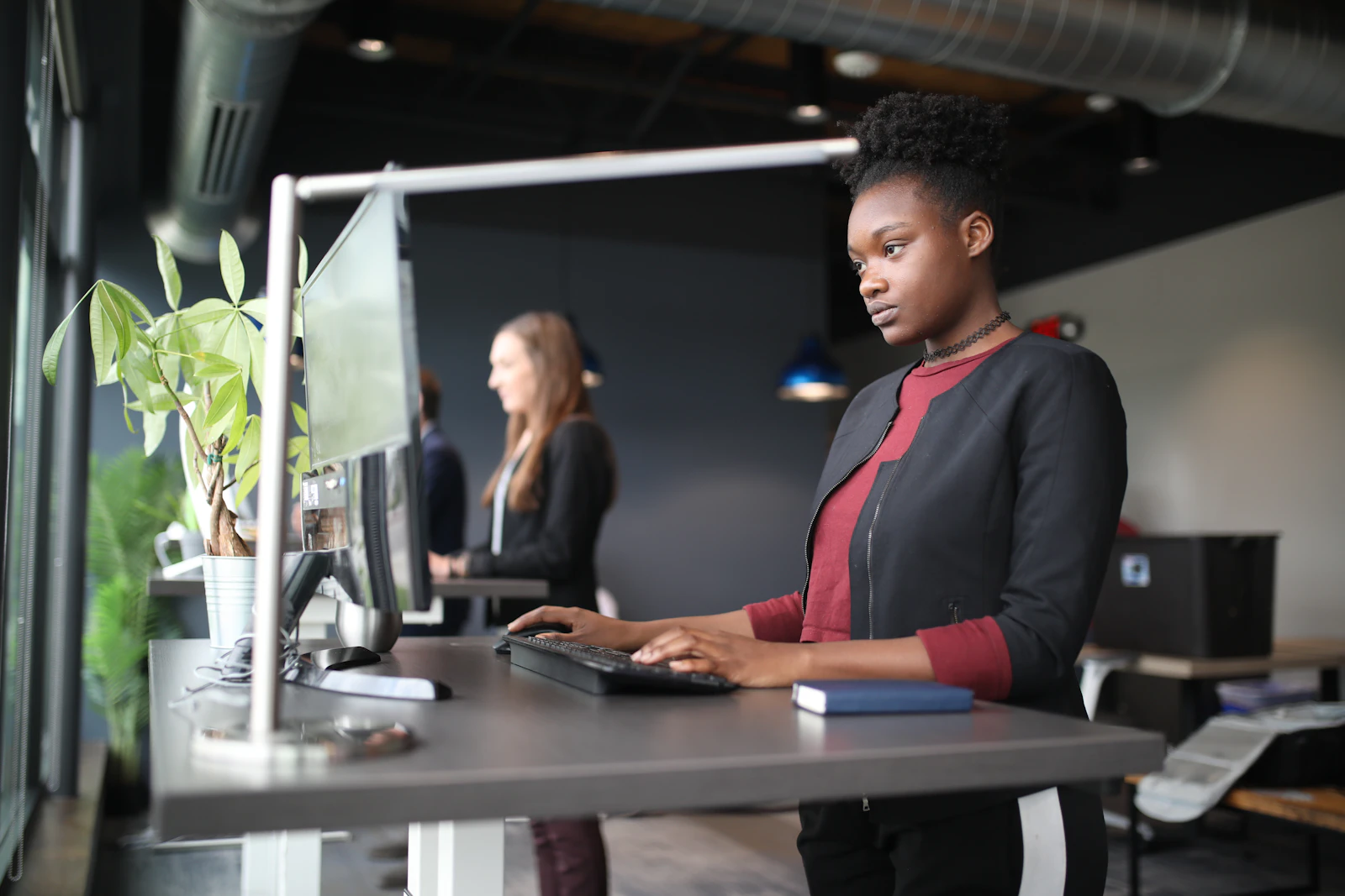 A woman standing at a desk using a computer