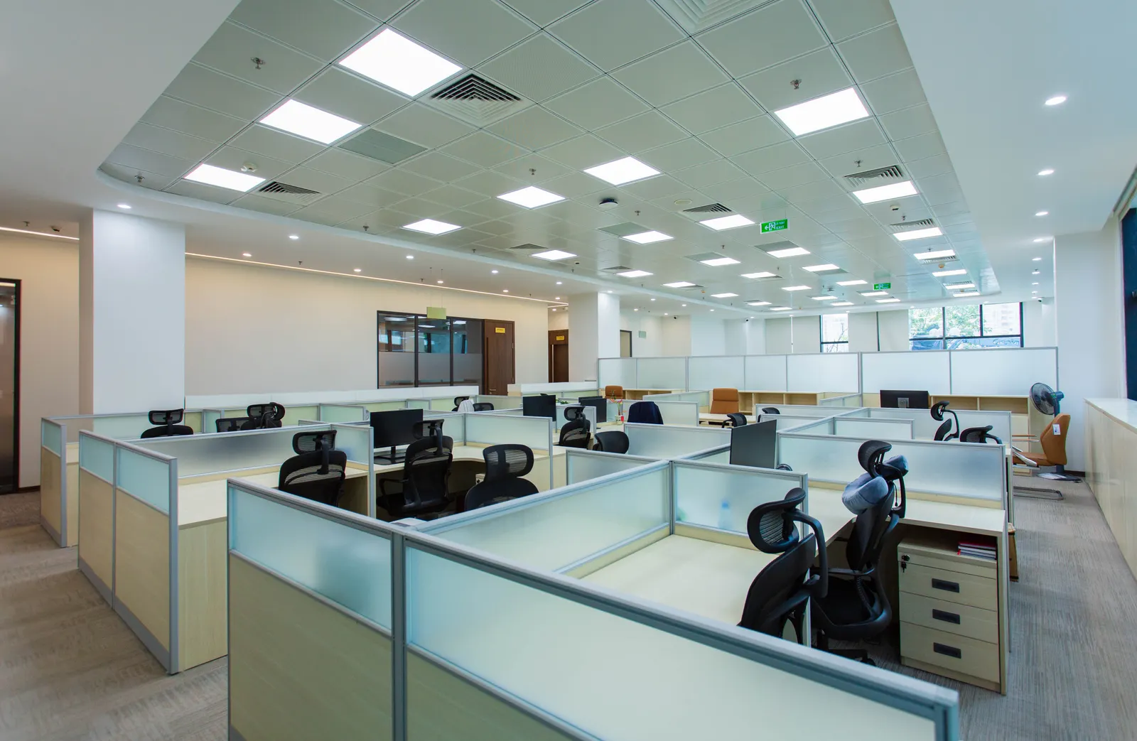 Spacious open-plan office with cubicles and modern furnishings, ideal for collaborative work environments